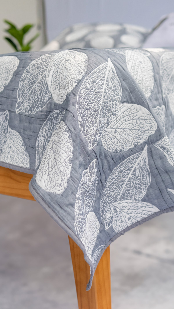 Elegant bedspread collection neatly displayed in a cozy bedroom setting, featuring soft textures, premium fabrics, and inviting neutral tones that blend seamlessly with modern decor.