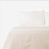 White Earthy Cobblestone Blanket on bed with pillows