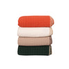 Stack of folded waffle throw blankets