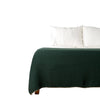 Green waffle throw blanket on bed